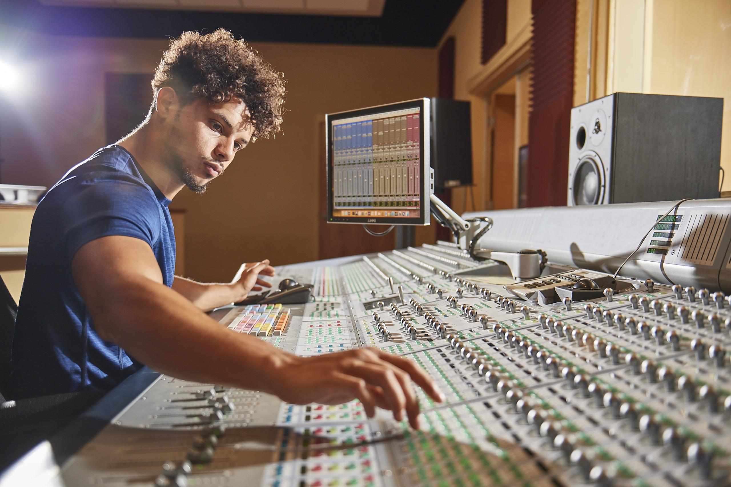 A male student working in a recording studio